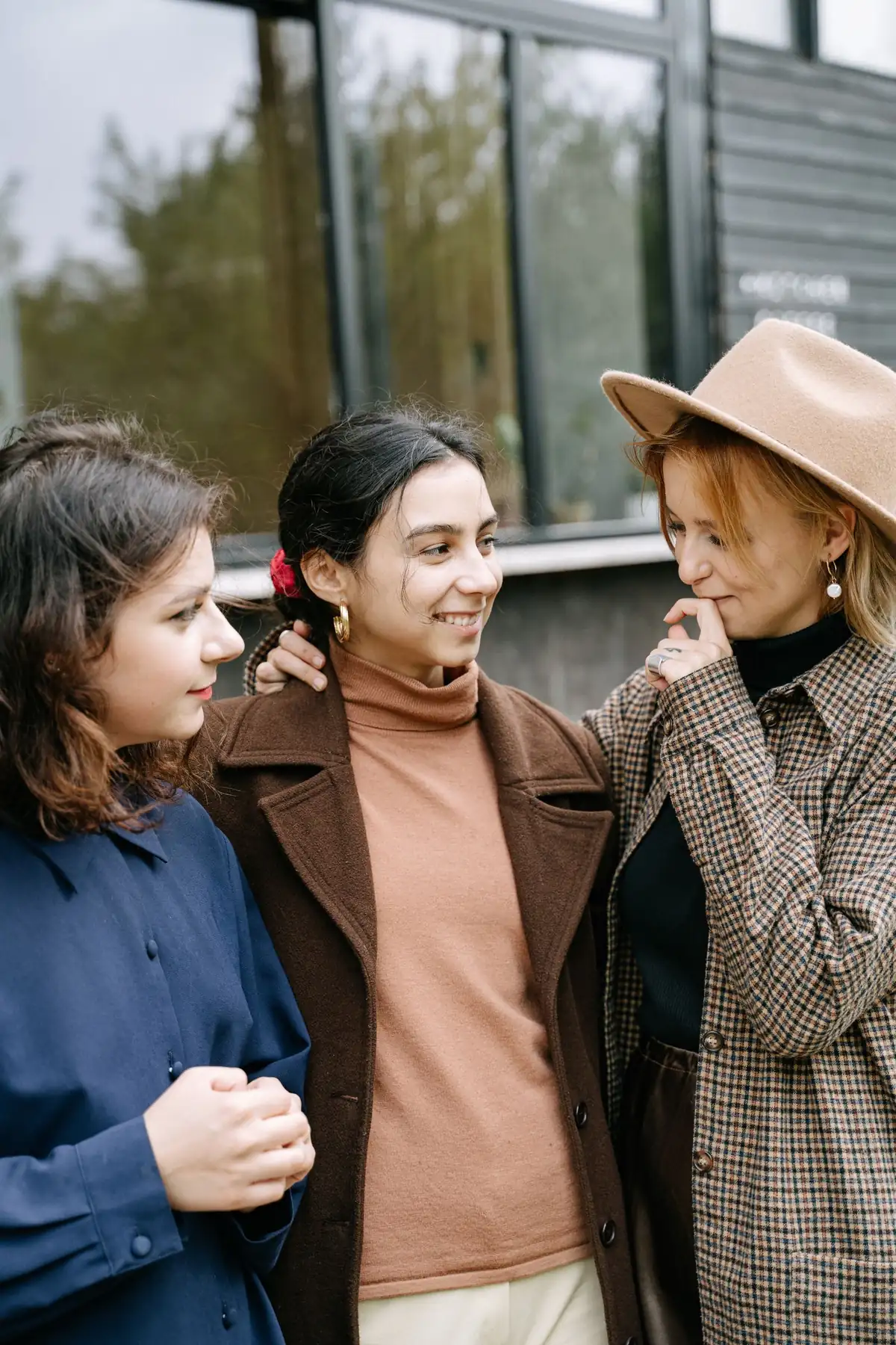 Three women smiling and talking together outdoors